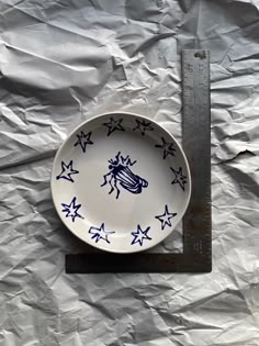 a plate with blue stars on it sitting on a piece of paper next to a ruler