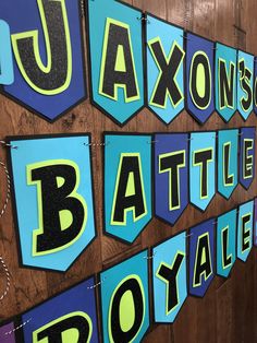 a wooden wall decorated with blue and yellow letters that spell out the word saxon battle royale