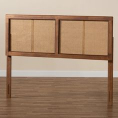 a wooden headboard with wicker panels on the top and bottom, against a beige wall