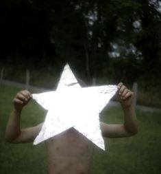 a person holding up a paper star in the air