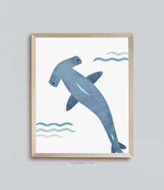 a blue dolphin in the ocean with waves on it's back, framed in wooden frame