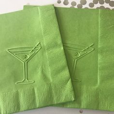 two lime green cocktail napkins sitting on top of each other with embroidered martini glasses