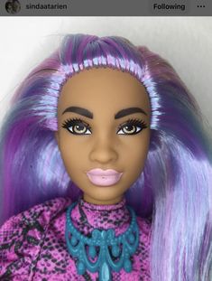 a close up of a doll with purple hair and blue eyeliners on her face