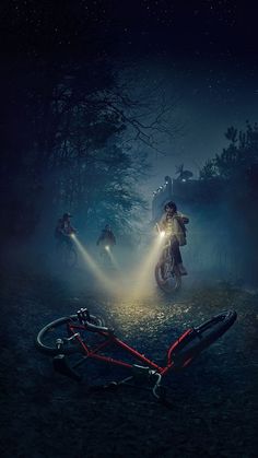 two people riding bikes in the woods at night with flashlights shining from their heads