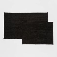 two black bath mats sitting next to each other