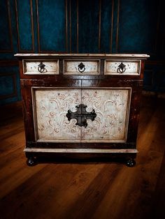 an old wooden chest with ornate carvings on it's sides and drawers, in a dark room