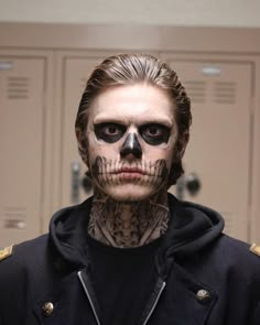 a man with skull makeup in a locker room