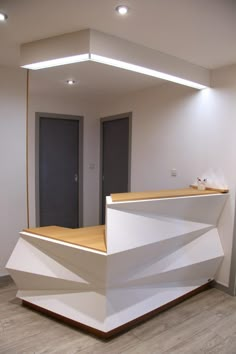 an empty reception area with white walls and wood flooring