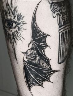 a man's leg with tattoos on it and an evil bat in the middle