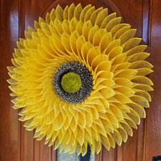 a large yellow sunflower hanging from the side of a door