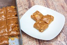 peanut butter squares on a plate next to a baking pan