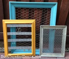 three different colored frames sitting next to each other in front of a fenced area