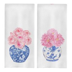 two hand towels with pink flowers in blue vases on white paper toweling set