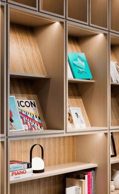 the bookshelves are lined up against the wall with wooden shelves and lamps on them