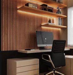 an office desk with a laptop computer on top of it next to a book shelf