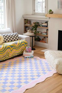 a living room filled with furniture and a fire place next to a couch on top of a hard wood floor