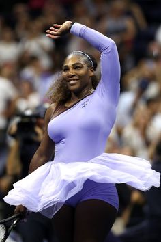 a female tennis player is holding her racket in one hand and smiling at the camera