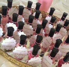 a tray filled with lots of pink and black bottles on top of a white table