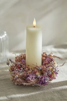 a white candle sitting on top of a table