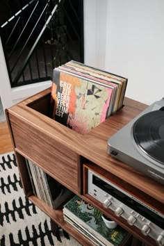 a record player sitting on top of a wooden table next to a shelf with records