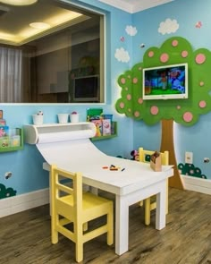 a child's playroom with a tree painted on the wall