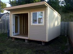 a small shed sitting in the middle of a yard