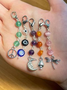 a person's hand holding several different charms