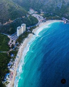 an aerial view of the beach and ocean with hotels in the background, taken from above