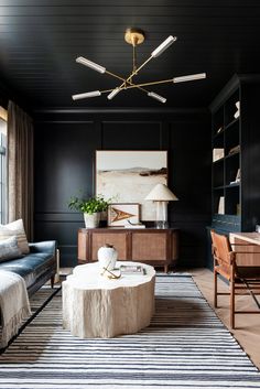 a living room with black walls and white rugs on top of the carpeted floor