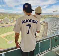 two baseball players are standing on the bleachers looking out at an empty stadium