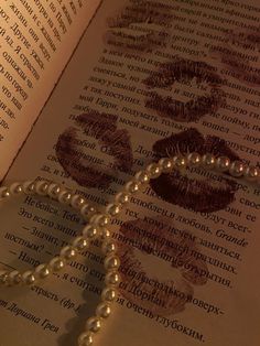 an open book with pearls and beads on it