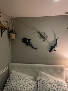 a bed with two pillows and some sea animals on the wall above it's headboard