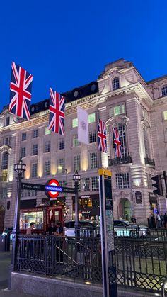 the british flag is flying in front of a large white building with black iron railings