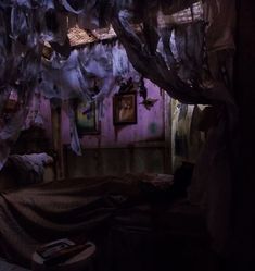 a room with curtains hanging from the ceiling, and a bed covered in cloths