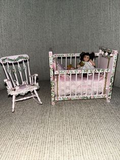 there is a doll in the crib next to a rocking chair