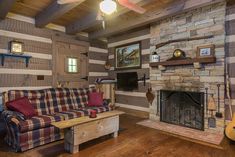 a living room with a couch, fireplace and guitar on the wall next to it