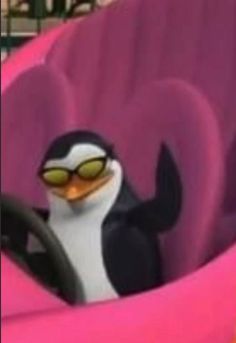 a cartoon penguin is sitting in a pink car seat with sunglasses on it's head