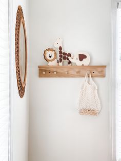 a wooden shelf with stuffed animals on it and a bag hanging from the wall next to it