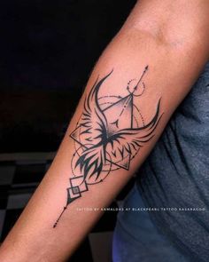 a black and white bird tattoo on the left arm, with geometric shapes around it