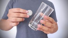 a man holding a glass with a coin in it