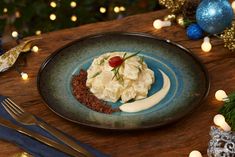 a blue plate topped with food on top of a wooden table next to christmas decorations