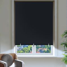 an empty chair in front of a window with black roller shades