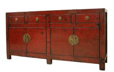 an old red wooden cabinet with brass handles