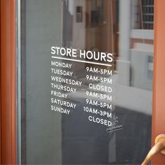 the store hours sign is posted on the glass door to the front of the building