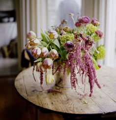 a vase filled with flowers sitting on top of a wooden table