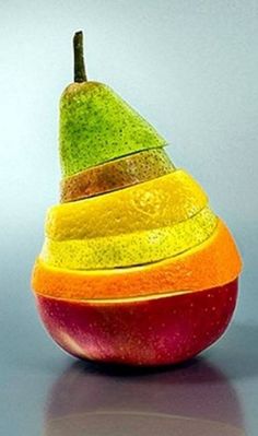 an orange, yellow and green apple sitting on top of a black table with grey background