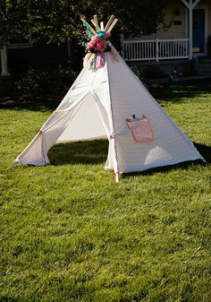 a teepee sitting on top of a lush green field