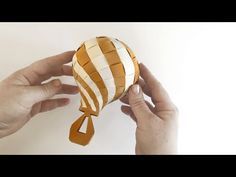 two hands holding an origami hot air balloon