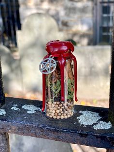 a jar filled with plants sitting on top of a wooden table next to a cemetery