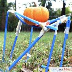 a pumpkin sitting on top of a blue chair in the grass